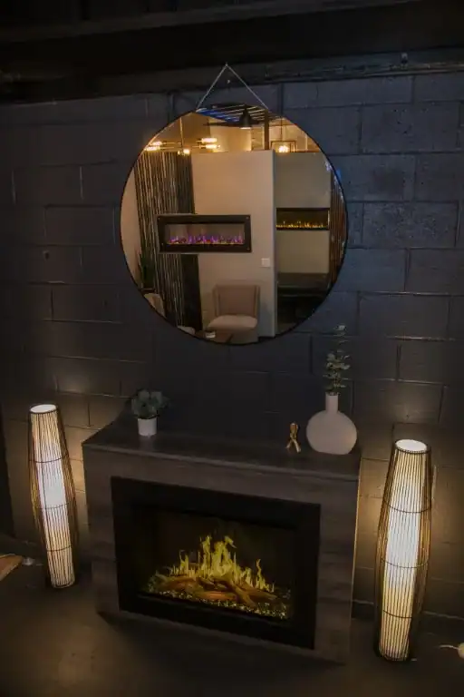 photo of an electric fireplace in a fireplace store with two more fireplaces in the reflection of the mirror above it.